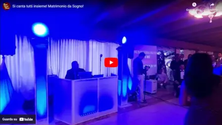 Sposi e ospiti che cantano insieme durante un matrimonio, creando un'atmosfera di festa e coinvolgimento con la musica dal vivo<br /><br />