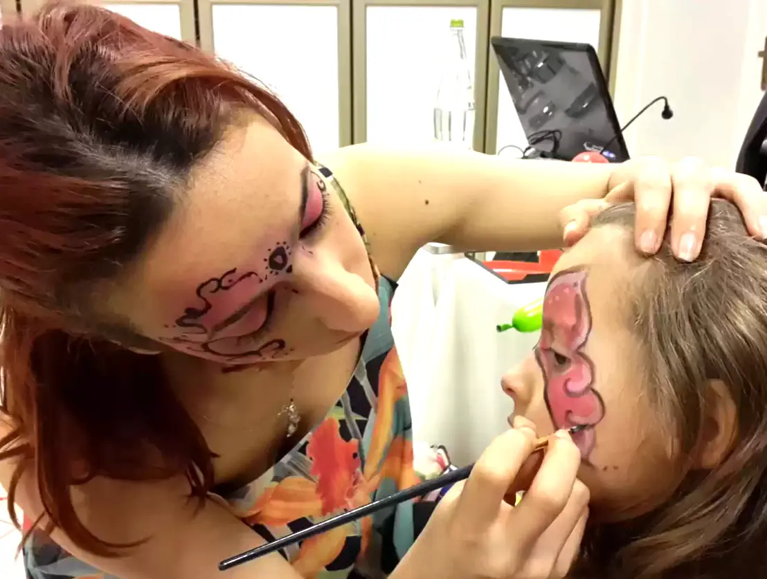 Animatrice che realizza trucca bimbi durante una festa di compleanno	